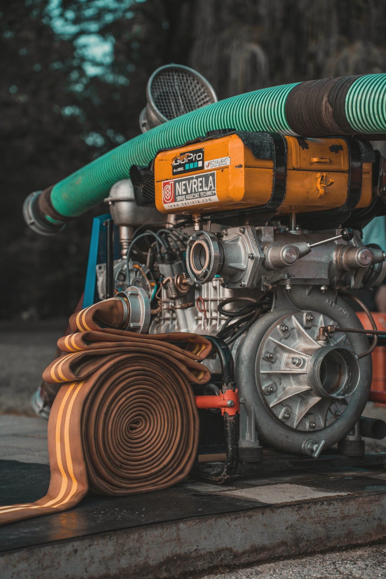 A pump unit with a large coiled suction hose beside it
