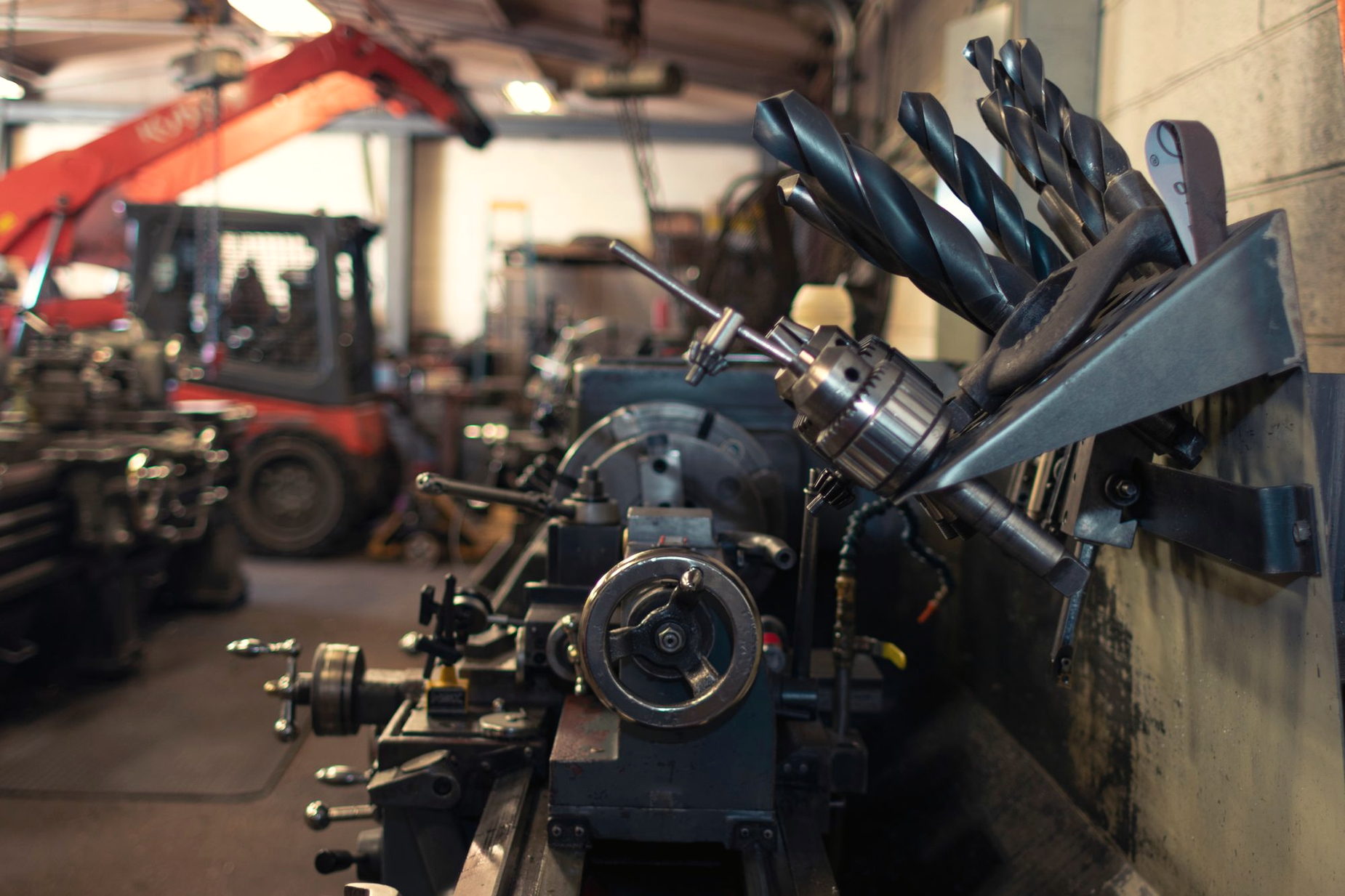 Shop tooling stored on a rack with machinery behind it
