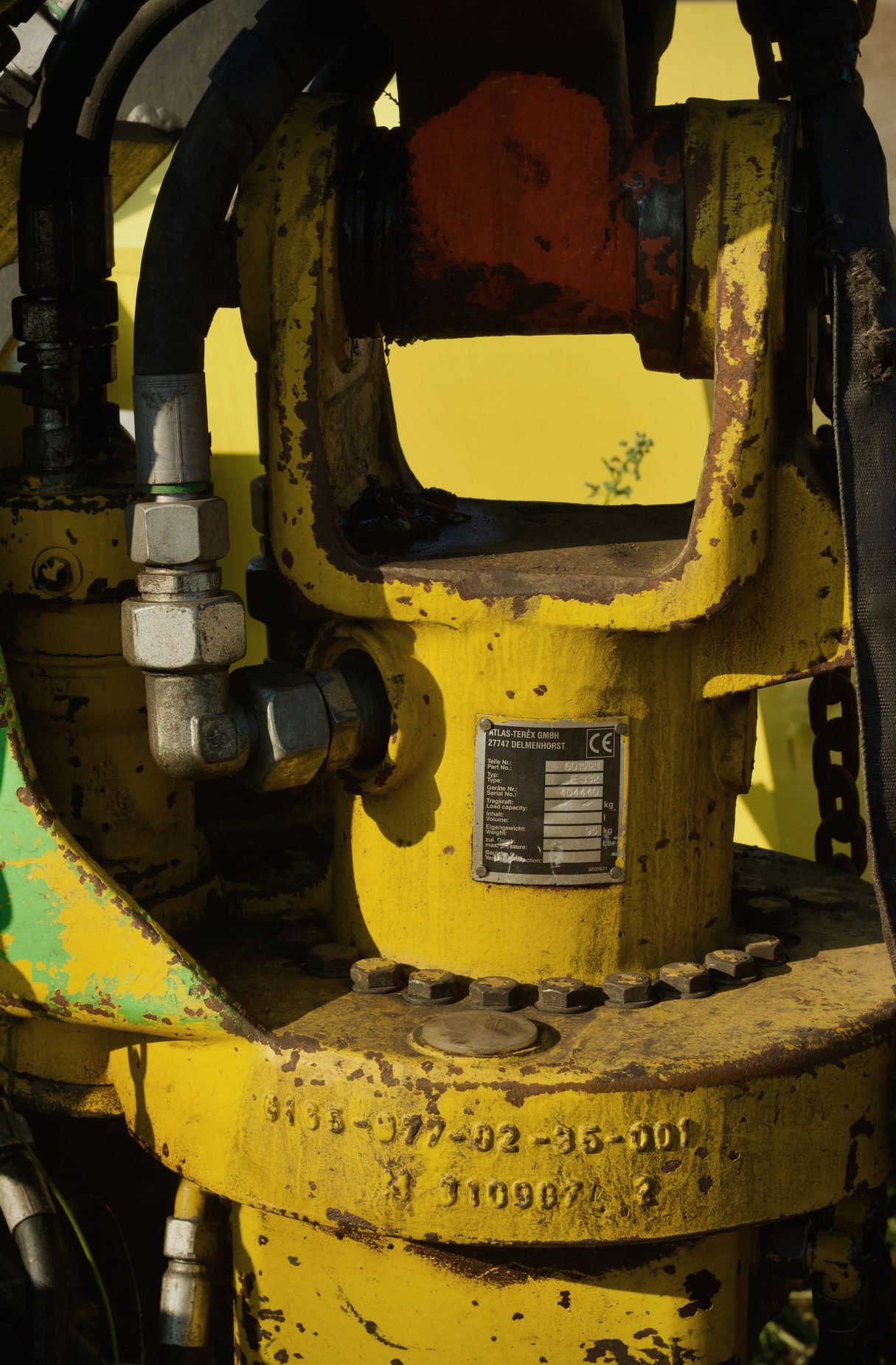 A yellow painted hydraulic valve body on a machine